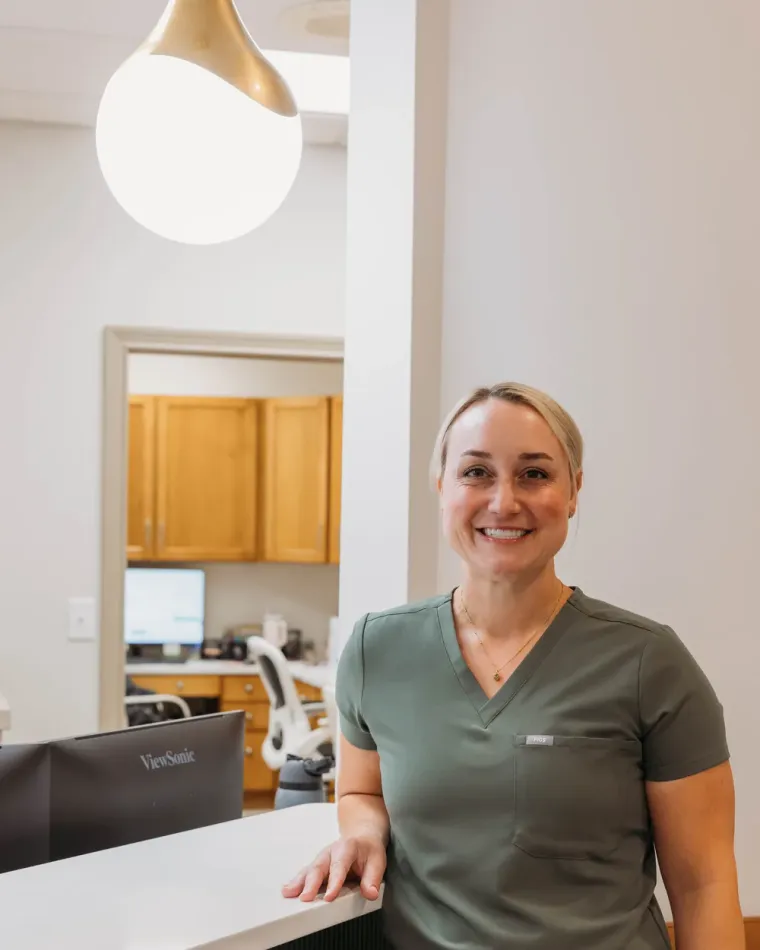 Dr. Kim Oberlander in green scrubs at the Cactus Pear Dental front desk