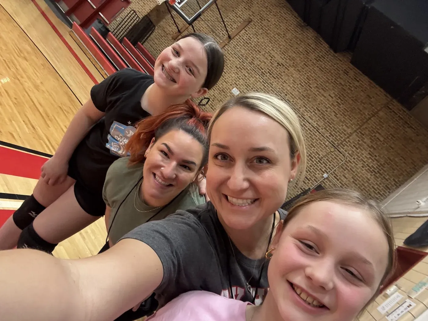 Dr. Oberlander in the gym with another coach and two volleyball players