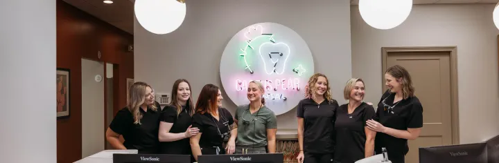 The Cactus Pear Dental team together behind the front desk